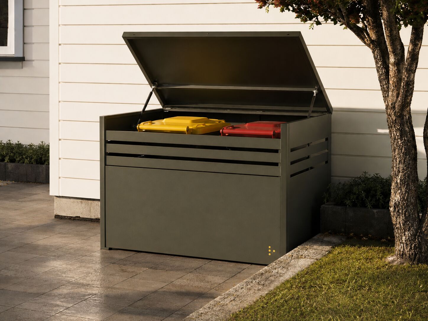 A CoverUp aluminium bin surround in matt olive Flaxpod on a tiled patio, lid raised on its gas struts, two wheelie bins visible inside